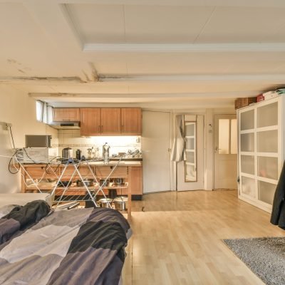 A spacious bright bedroom with a large tv, lamps and panoramic window